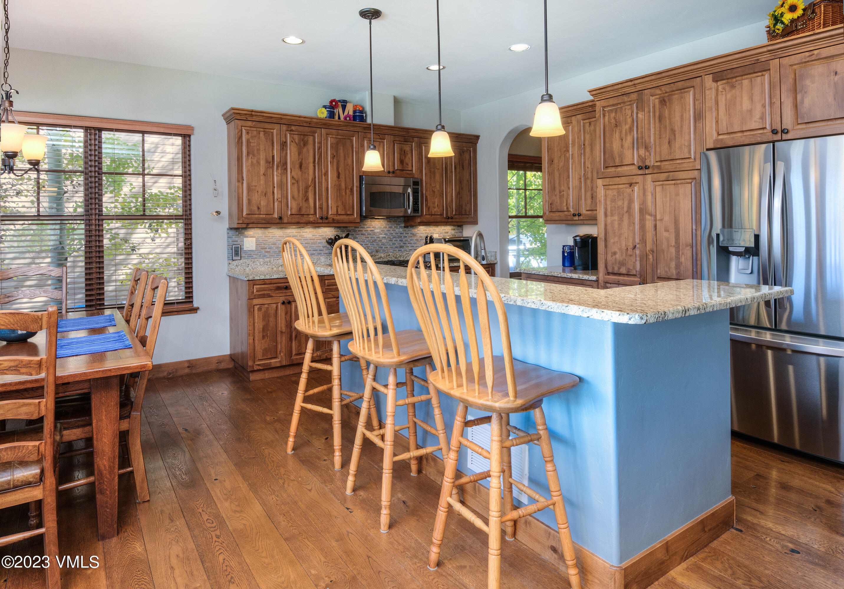 346 Palmer Loop Eagle, CO 81631 - Photo 15 of 63 a kitchen with stainless steel appliances kitchen island granite countertop a table chairs and a large window