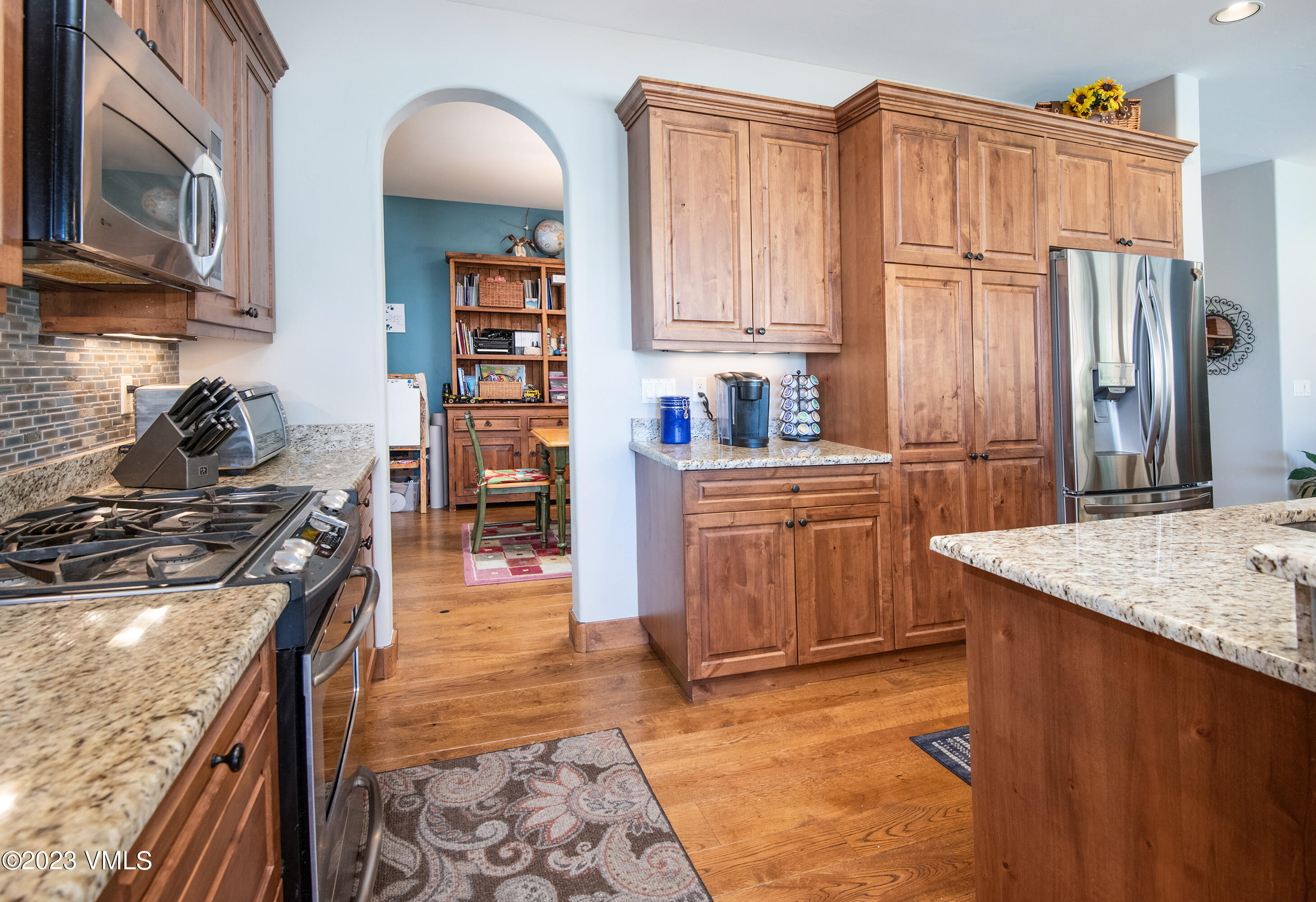 346 Palmer Loop Eagle, CO 81631 - Photo 16 of 63 a kitchen with stainless steel appliances granite countertop a stove top oven a sink dishwasher and cabinets with wooden floor