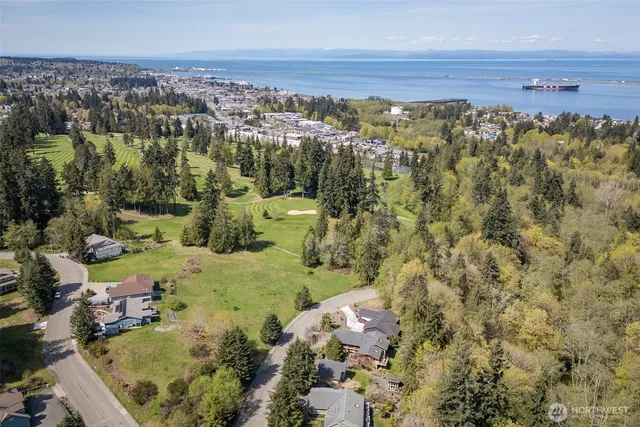 an aerial view of a houses with a yard and lake view