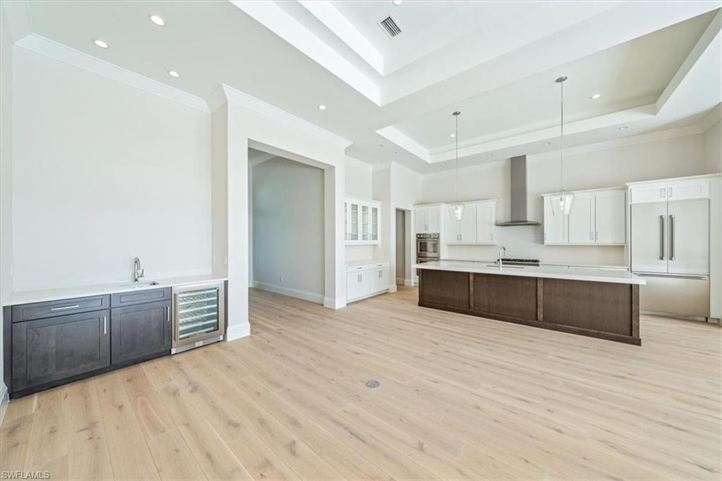 23511 Coconut Road Estero, FL 34134 - Photo 15 of 50 a large white kitchen with kitchen island a sink stainless steel appliances and cabinets