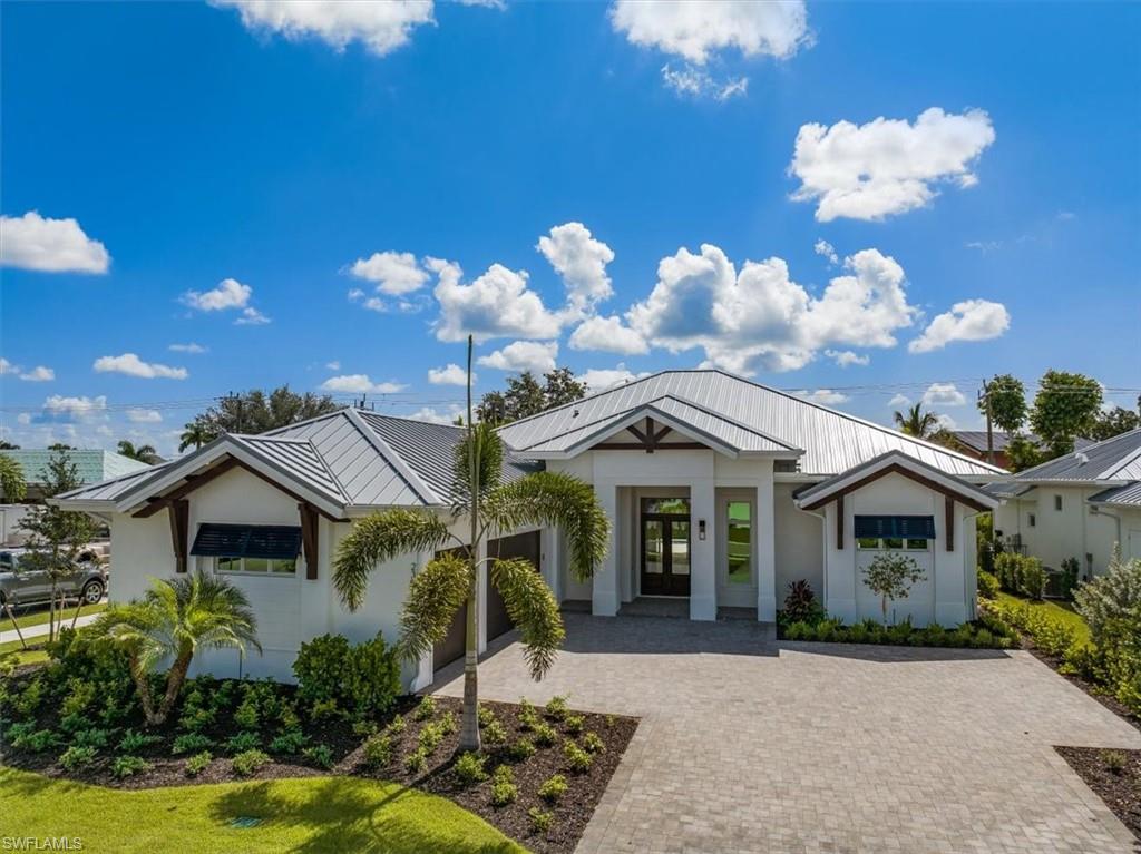 23511 Coconut Road Estero, FL 34134 - Photo 2 of 50 a front view of a house with a yard and a garden
