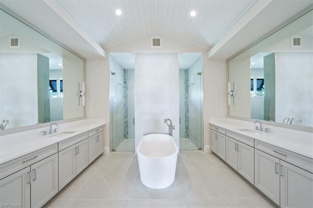 23511 Coconut Road Estero, FL 34134 - Photo 22 of 50 a bathroom with a double vanity sink a toilet and mirror
