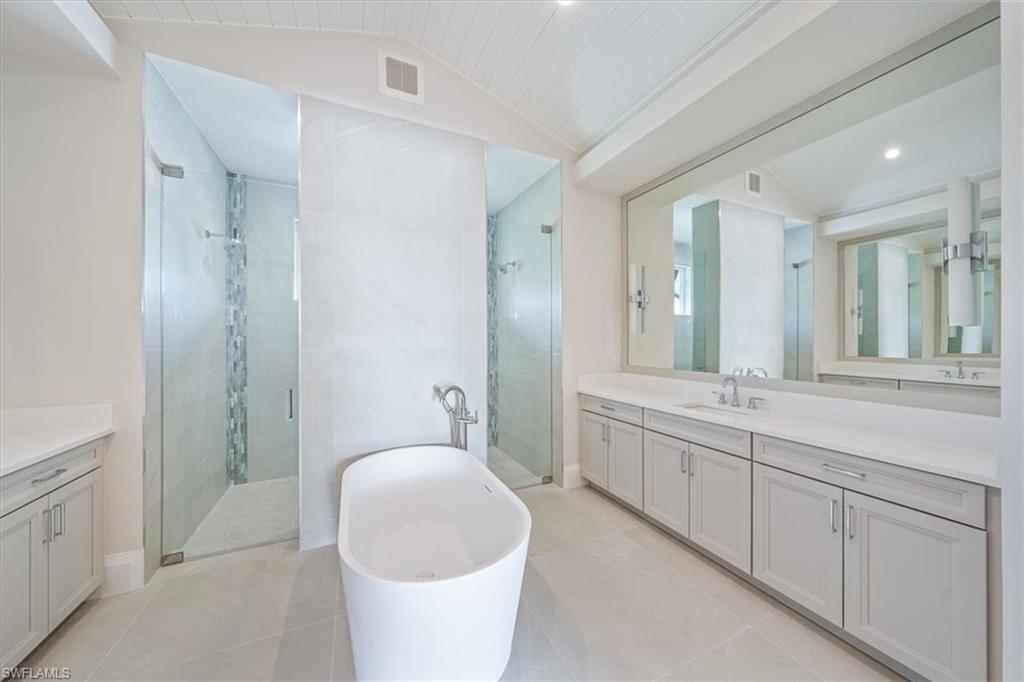 23511 Coconut Road Estero, FL 34134 - Photo 23 of 50 a spacious bathroom with a double vanity sink a mirror and a bathtub