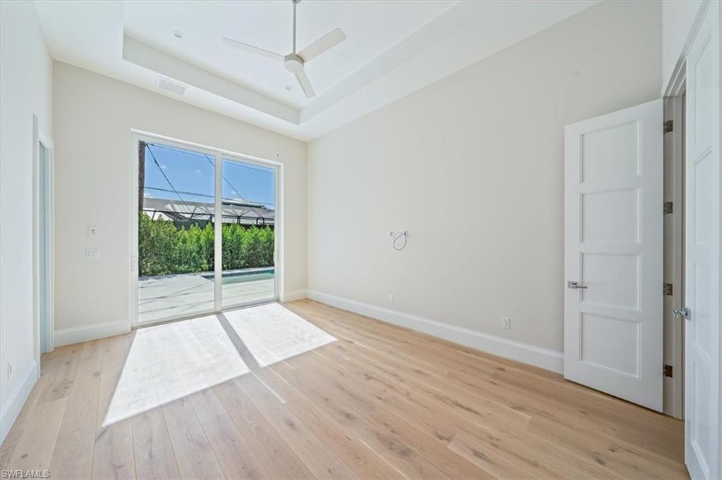 23511 Coconut Road Estero, FL 34134 - Photo 30 of 50 an empty room with wooden floor fan and windows