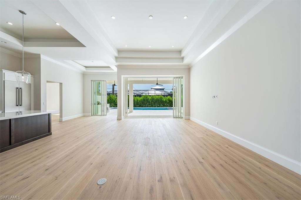 23511 Coconut Road Estero, FL 34134 - Photo 3 of 50 an empty room with wooden floor and windows