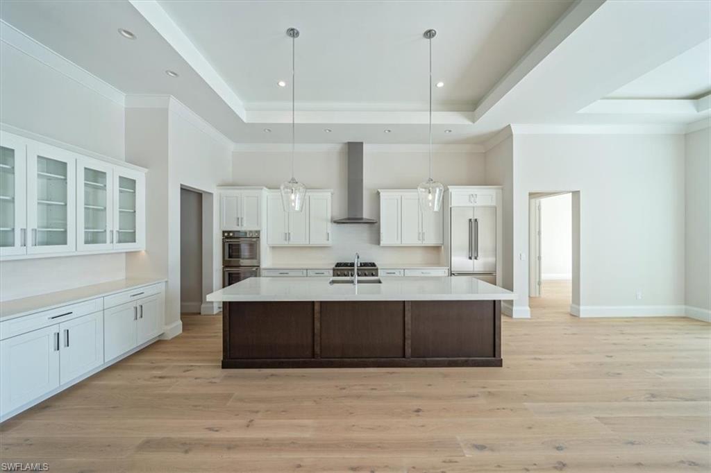 23511 Coconut Road Estero, FL 34134 - Photo 6 of 50 a large white kitchen with a large island oven a sink stainless steel appliances and cabinets