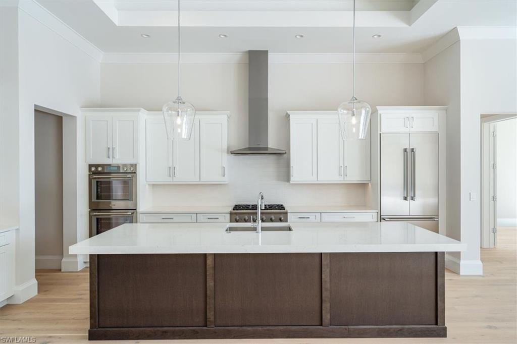 23511 Coconut Road Estero, FL 34134 - Photo 7 of 50 a kitchen with stainless steel appliances a stove a sink and white cabinets