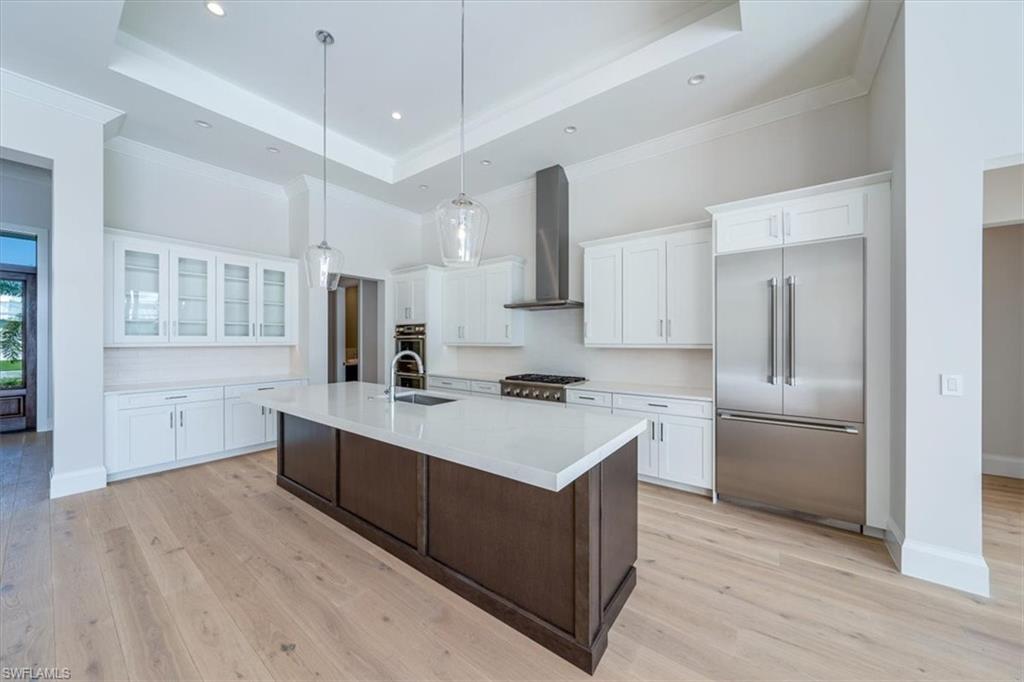 23511 Coconut Road Estero, FL 34134 - Photo 8 of 50 a kitchen with white cabinets and stainless steel appliances