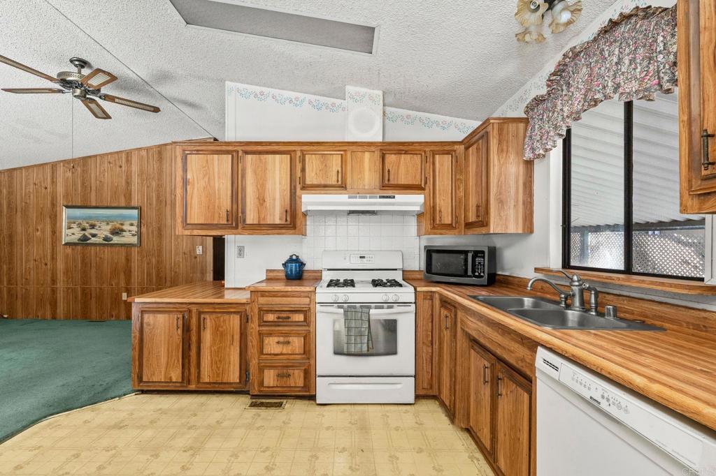 11949 Riverside Drive, Unit 23 Lakeside, CA 92040 - Photo 12 of 35 a kitchen with stainless steel appliances granite countertop a sink stove and refrigerator