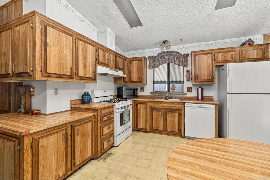 11949 Riverside Drive, Unit 23 Lakeside, CA 92040 - Photo 13 of 35 a kitchen with a white cabinets and white appliances