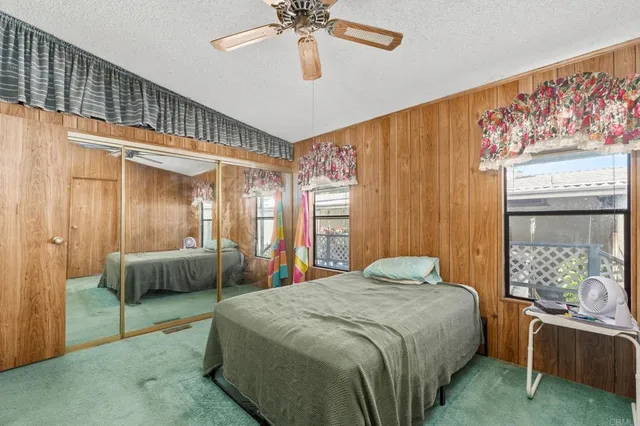 a bed sitting in a spacious bedroom next to a window