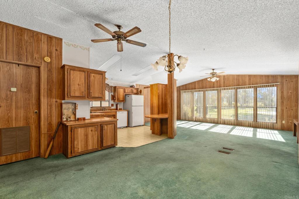 11949 Riverside Drive, Unit 23 Lakeside, CA 92040 - Photo 7 of 35 a view of a kitchen with a stove cabinets a ceiling fan and wooden floor