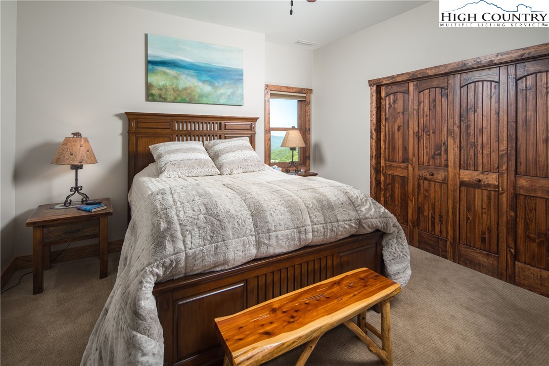 421 Chappell Farm Road Banner Elk, NC 28604 - Photo 33 of 49 a bedroom with a bed and a chandelier