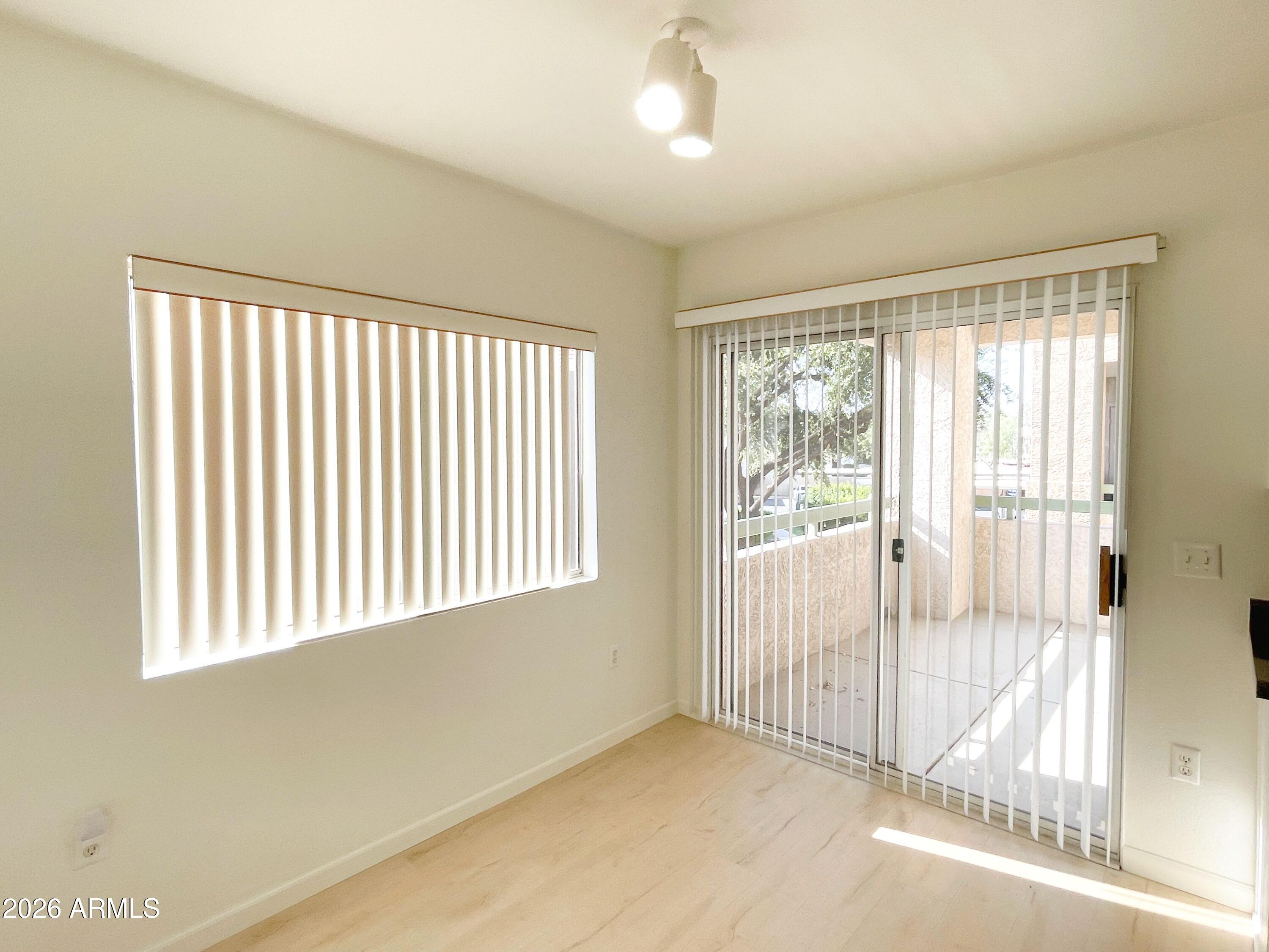 1295 North Ash Street, Unit 828 Gilbert, AZ 85233 - Photo 9 of 24 an empty room with wooden floor and windows