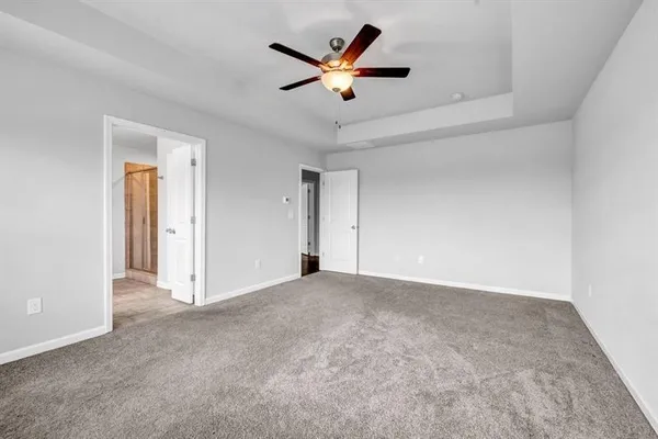 an empty room with closet and ceiling fan