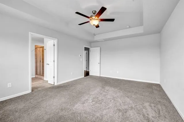 an empty room with closet and ceiling fan