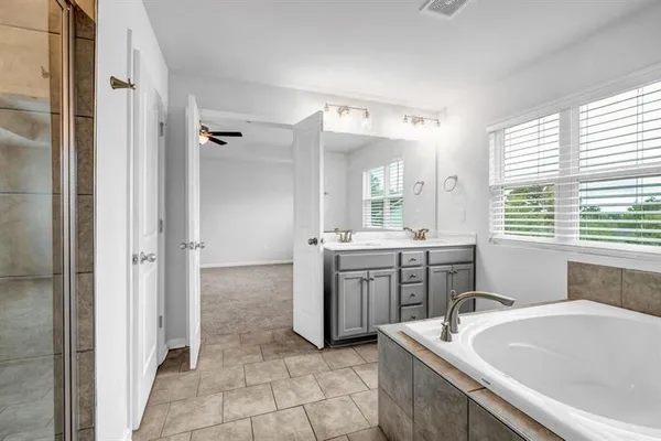 a bathroom with a tub sink and mirror