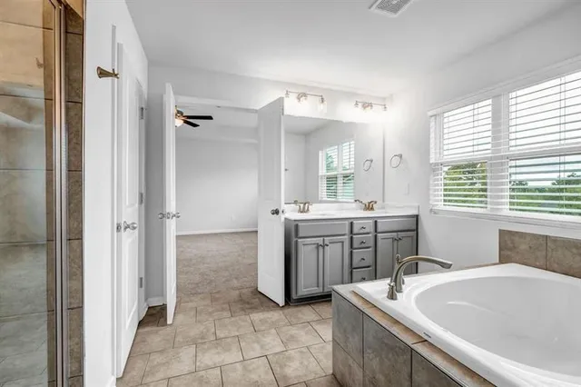 a bathroom with a tub sink and mirror