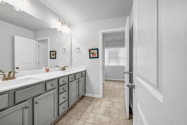a spacious bathroom with a double vanity sink a mirror and a