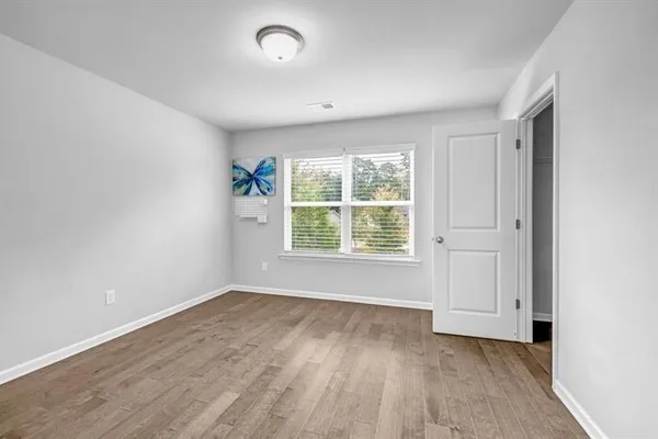 an empty room with wooden floor and windows