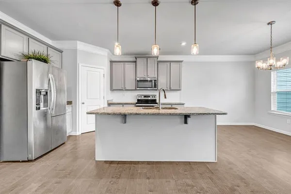 a kitchen with stainless steel appliances granite countertop a refrigerator a sink and a stove