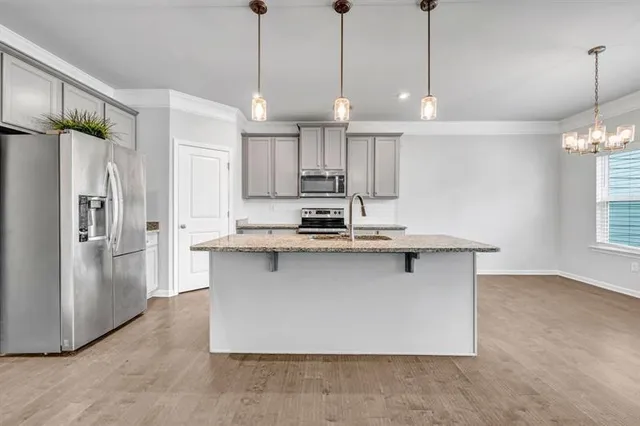 a kitchen with stainless steel appliances granite countertop a refrigerator a sink and a stove