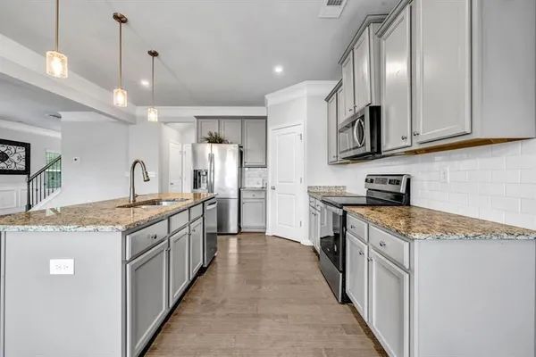 a large kitchen with stainless steel appliances granite countertop a sink stove and cabinets