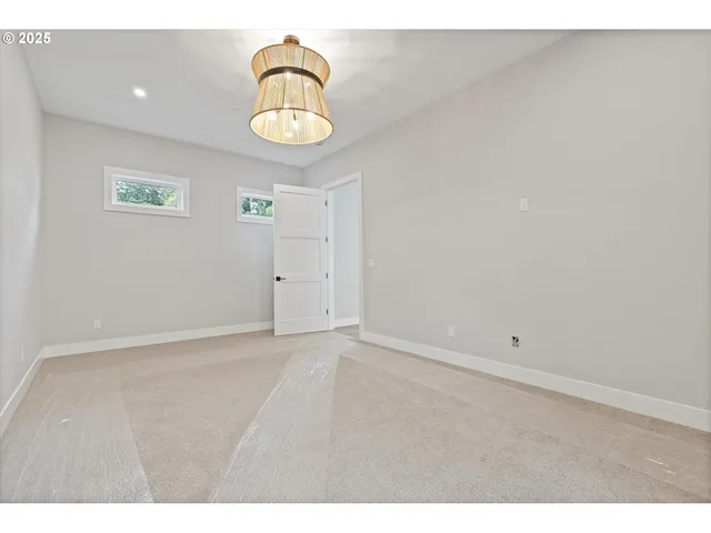 a view of an empty room and a chandelier fan