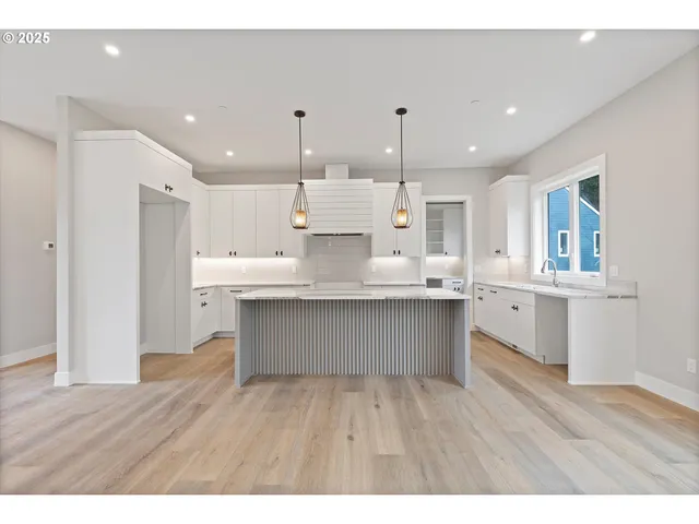 a kitchen with stainless steel appliances granite countertop a wooden floors and view living room