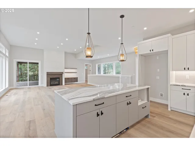 a kitchen with kitchen island a stove a sink a center island and a window