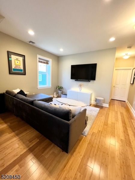 28 Gates Avenue, Unit A Summit, NJ 07901 - Photo 3 of 8 a living room with a couch and a flat screen tv