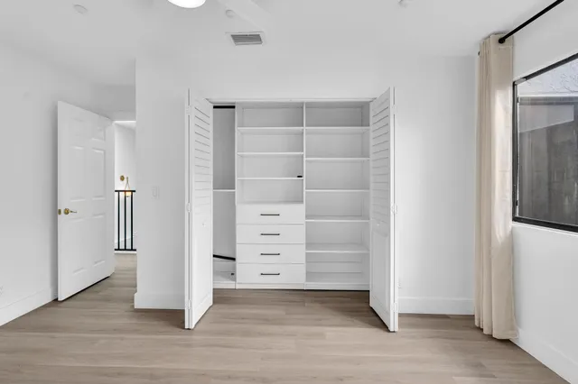 a view of an empty room with wooden floor