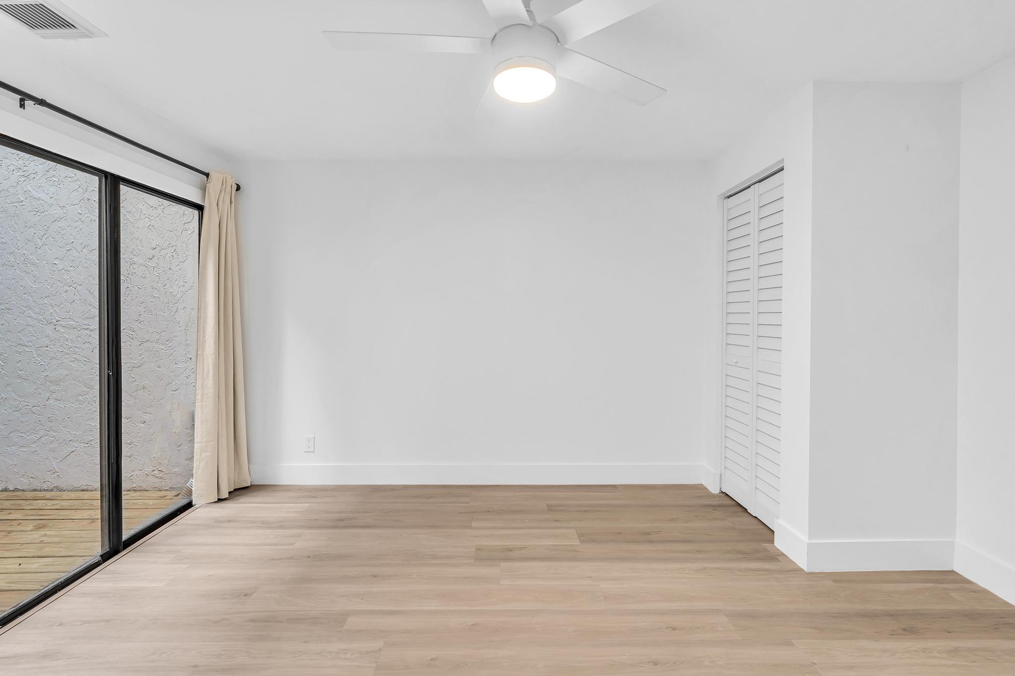 6565 Parkview Drive, Unit C Boca Raton, FL 33433 - Photo 24 of 40 a view of an empty room with wooden floor and a window
