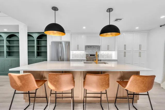 a kitchen with stainless steel appliances granite countertop a sink a stove and a refrigerator