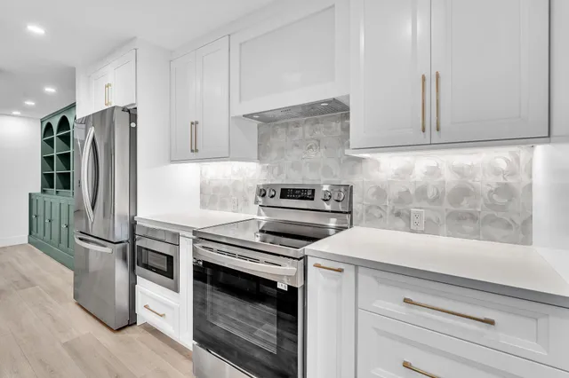a view of a kitchen with wooden floor and cabinets
