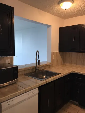 a kitchen with a refrigerator and a sink