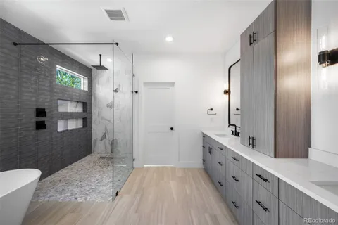 a bathroom with a double vanity sink mirror and shower