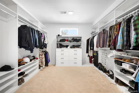 a view of walk in closet with clothes and shoes