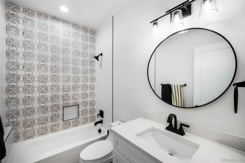 a bathroom with a sink a toilet and a mirror