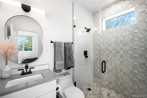 a bathroom with a toilet sink and a mirror