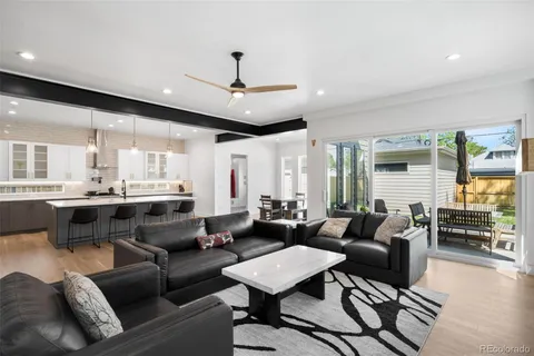 a living room with furniture kitchen view and a large window