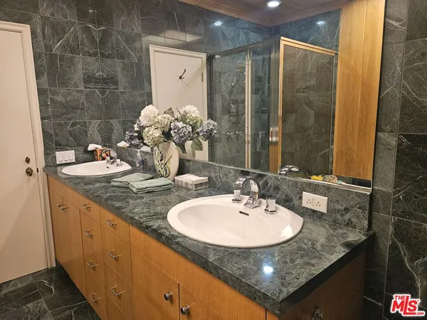 a bathroom with a granite countertop sink and a mirror