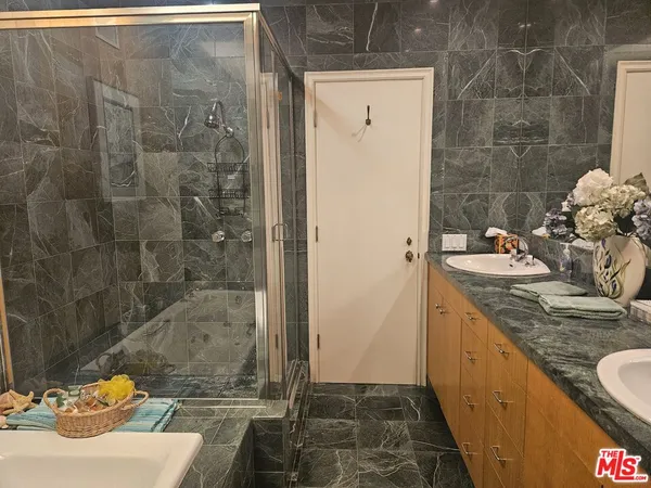 a bathroom with a granite countertop sink a toilet and shower