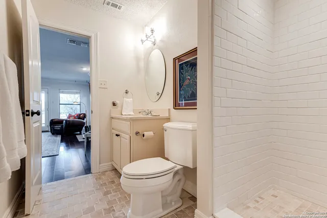 a bathroom with a toilet a sink and mirror