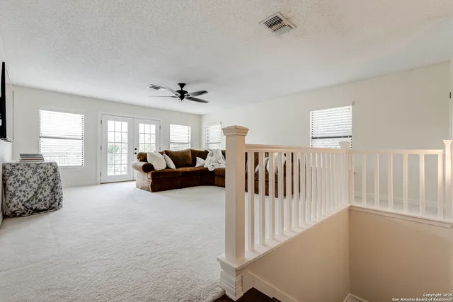 a living room with furniture ceiling fan and a window
