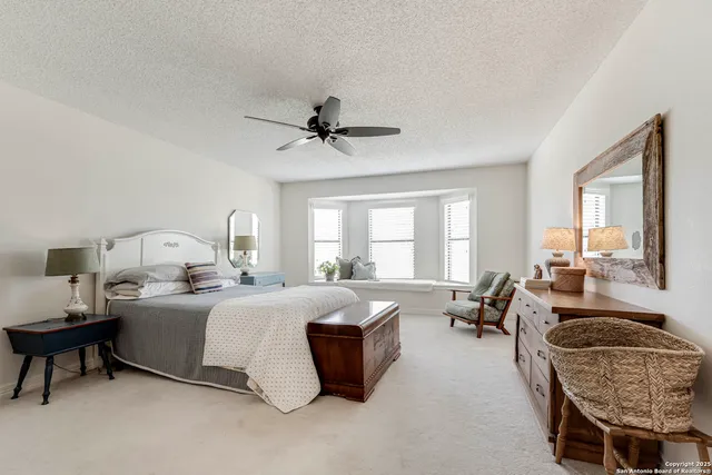 a spacious bedroom with a bed a couch and a window