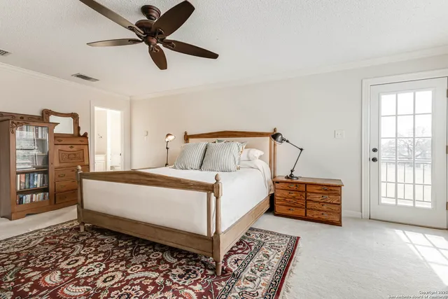 a bedroom with a bed next to a window and a chandelier