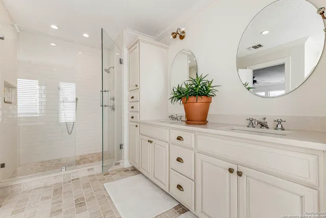 a bathroom with a granite countertop sink a mirror and shower