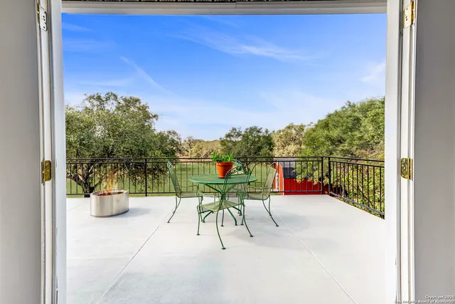 a view of two chairs and table in a balcony