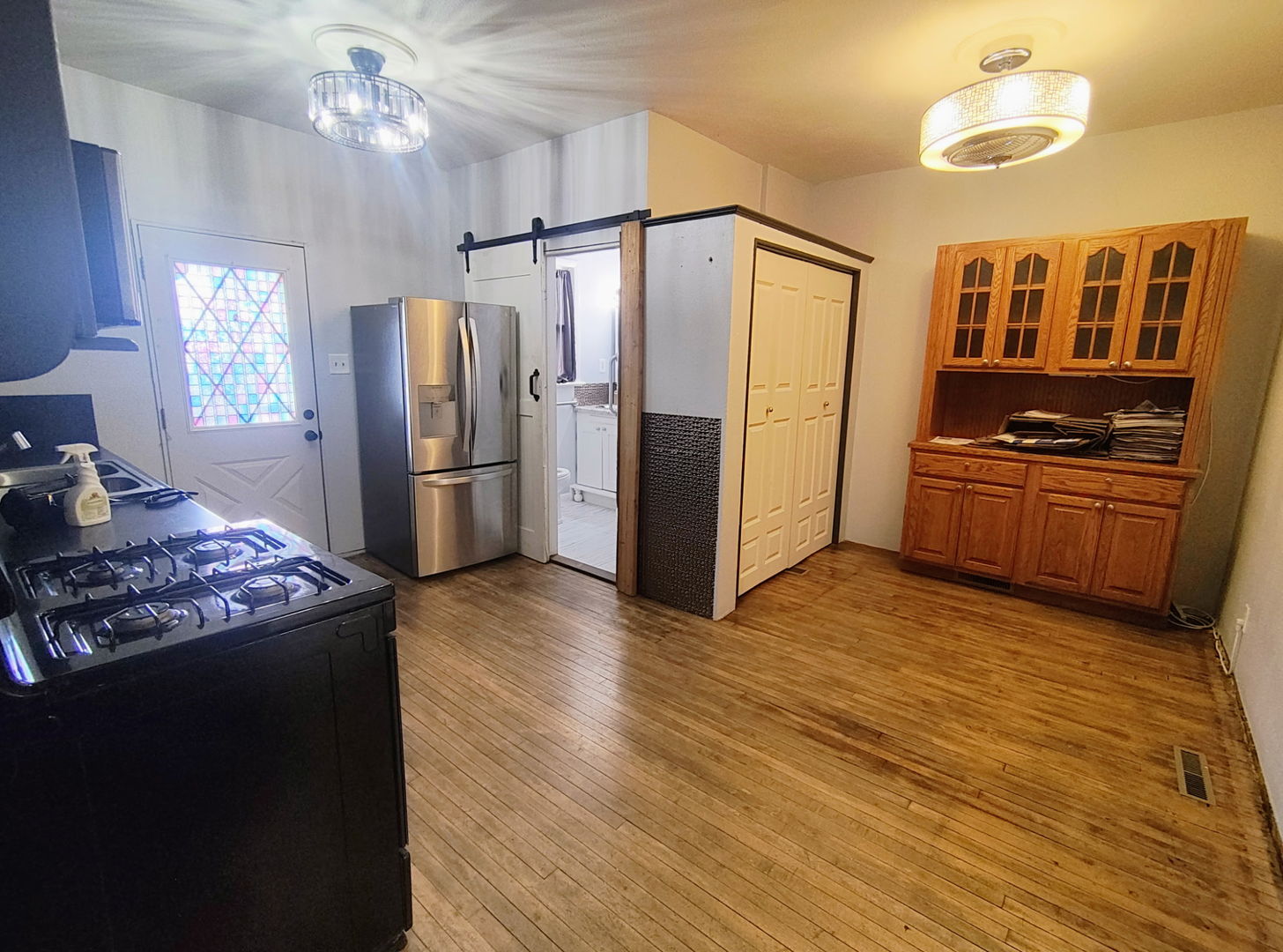 1041 West Dakota Street Spring Valley, IL 61362 - Photo 6 of 15 a kitchen with stainless steel appliances granite countertop a refrigerator a stove a sink dishwasher a dining table and chairs with wooden floor